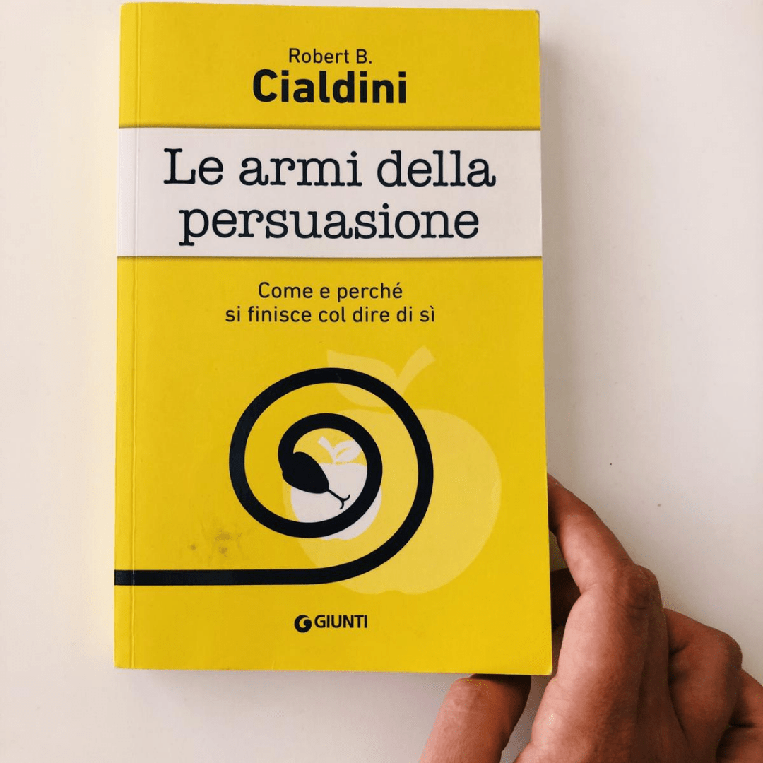 libro le armi della persuasione come si finisce per dire di si. copertina gialla con spirale che forma un serpente nero